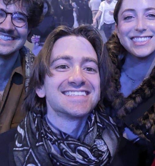 Andre smiling, with friends behind him